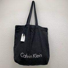 Black Calvin Klein Tote Bag, Light Weight Chic Black Canvas Bag With Removable Pouch, Chic Black Canvas Bag With Dust Bag, Chic Black Canvas Bag With Adjustable Strap, Black Canvas Bag With Removable Pouch For Shopping, Black Canvas Bag With Adjustable Strap For Shopping, Chic Black Canvas Tote Bag, Black Canvas Shopping Bag, Chic Black Everyday Canvas Bag, Casual Shoulder Bag With Dust Bag For Shopping