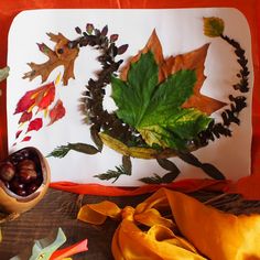 an arrangement of autumn leaves and acorns on a table