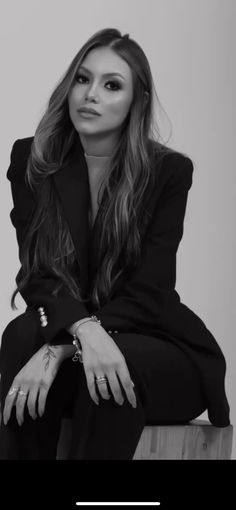 a woman sitting on top of a wooden table next to a black and white photo