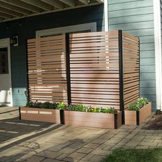 a wooden planter sitting on the side of a house