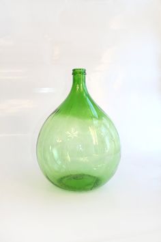 a green vase sitting on top of a white table