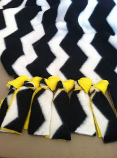 black and white chevroned scarf with yellow bows on it's ends, sitting on a table