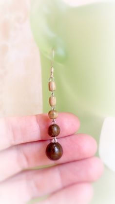 "This elegant pair of earrings made of two colors wooden  beads :  dark brown and green . The hooks are surgical steel silver plated . Very lightweight . Lovely simple  design !  Size : 1 \"  1/2 '  long             4 mm  - diameter of small brown ball            10 mm - diameter of larger brown color balls If you'll have any questions - welcome to contact me ! Here you can find collection of wood earrings : https://www.etsy.com/shop/TheWoodenTreasures?ref=listing-shop2-all-items-count&section_i Brown Wooden Bead Drop Earrings, Brown Wooden Drop Earrings, Brown Wood Drop Earrings, Brown Wooden Earrings For Pierced Ears, Brown Wooden Earrings As Gift, Brown Wooden Dangle Jewelry, Brown Wooden Bead Earrings As A Gift, Handmade Wooden Drop Earrings, Brown Earrings With Wooden Beads As Gift