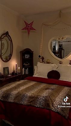 a leopard print comforter on a bed in a room with two candles and a mirror