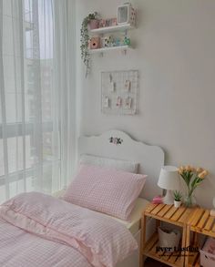 a bedroom with pink bedding and white walls