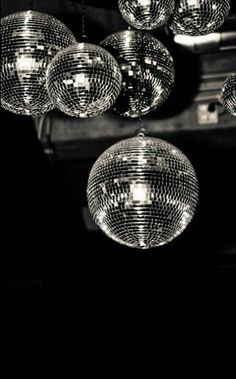 disco balls hanging from the ceiling in black and white