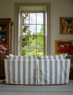 a striped couch sitting in front of a window