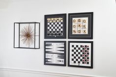 four framed art pieces hang on the wall next to each other, including a chess board and checkerboard