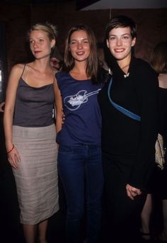 three women standing next to each other at a party