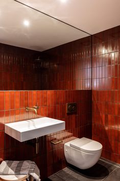 a bathroom with a toilet, sink and mirror on the wall next to each other