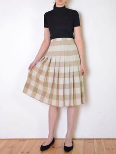 Cool vintage skirt made of gently textured, matte fabric - woven with plaid pattern in tones of beige and white. Flared, a line midi fit. Button and zip closure on the back. Unlined. The item has been pinned on the model Era: 70's Fabric: not given, feels like cotton to touch Condition: very good Estimated size: L / XL (please, check the measurements) Measurements (measured flat, need to be doubled to get the circumference): Waist: 45 cm / 17,7 inches Length: 72 cm / 28,3 inches Beige A-line Pleated Skirt For Fall, Chic Pleated Plaid Skirt, Summer Plaid Pleated Skirt, Classic Box Pleat Pleated Skirt For Summer, Fall Fitted Skirt With Box Pleat, Fitted Box Pleat Skirt For Fall, Chic Plaid Pleated Skirt, Classic Pleated Plaid Skirt, Fitted Beige Pleated Skirt For Fall