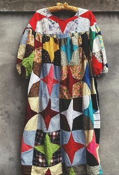 a colorful patchwork dress hanging on a wall