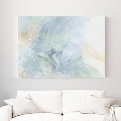 a living room with a white couch and large painting on the wall above it's head