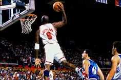 an image of a basketball player going to dunk the ball in front of his opponent