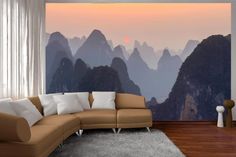 a living room with mountains in the background and a large couch on the far side