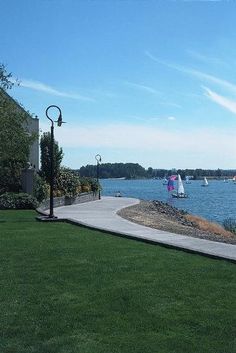 there are many sailboats in the water on this sunny day at the lakefront