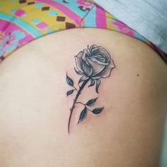 a woman's stomach with a rose tattoo on it