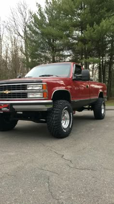 a red pickup truck parked in a parking lot