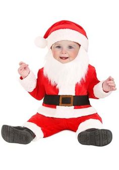 a baby dressed as santa clause sitting on the floor with his hands in the air