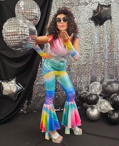 a woman is posing in front of disco balls