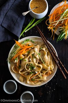 a bowl filled with noodles and vegetables next to chopsticks