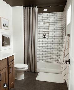 a bathroom with a toilet, tub and shower curtain in it's center area