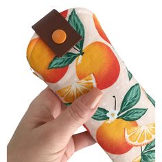 a hand holding an orange and brown case