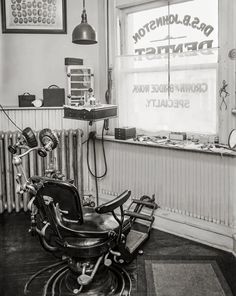 a black and white photo of a dentist's office with an old fashioned barber chair