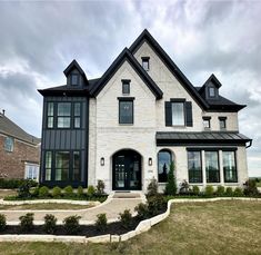 a large white brick house with black trim