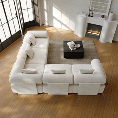 a white couch sitting on top of a hard wood floor next to a fire place