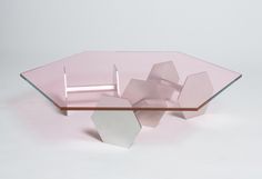 a pink glass table with geometric shapes on it