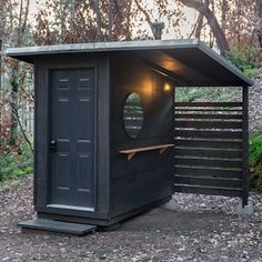 a small outhouse in the middle of a wooded area