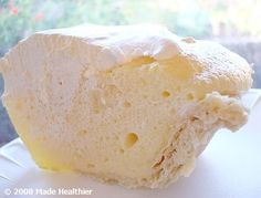 a piece of bread sitting on top of a white plate next to a glass window