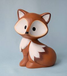 a brown and white fox figurine sitting on top of a table