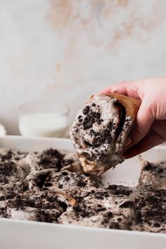 a person is holding a cookie doughnut in their left hand and it has chocolate chips on top