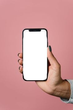 a person holding up a cell phone with a white screen in their hand on a pink background