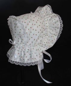 A beautiful Victorian style baby bonnet. Fabric is white searsucker with rosebuds. Lining is white . Bonnet has an extended back and is trimmed with white lace. Bows and extra long ties are made of white double sided satin ribbon. Size/ Measurement from under ear lobe around top of head to under other ear lobe preemie / 10 inches 0-3 months / 11 inches 3-6 months / 12 inches 6-9 months / 13 inches 9-12 months / 14 inches 12-18 months/ 15 inches Fitted White Bonnet With Lace Trim, Cute Fitted White Bonnet, Cute White Fitted Bonnet, White Fitted Hat With Lace Trim, Adjustable Cotton Bonnet With Lace Trim, Fitted Cotton Bonnet With Lace Trim, White Fitted Vintage Bonnet, White Bonnet, Newborn Bonnet