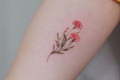 a small flower tattoo on the left thigh and right leg, with pink carnations growing out of it