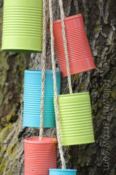 colorful buckets hanging from a tree with rope