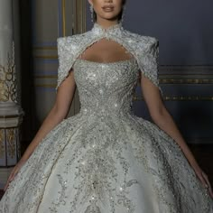 a woman in a ball gown with an open back and beading on the shoulders