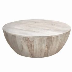 a round wooden table sitting on top of a white floor