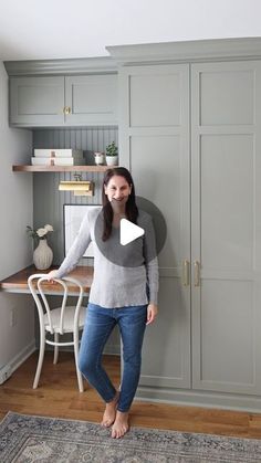 a woman standing in front of a gray cabinet