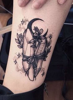 a woman's arm with a tattoo on it that has an arrow and stars