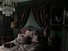 a bed sitting under a chandelier in a bedroom next to a window with curtains