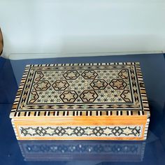 a wooden box sitting on top of a blue table