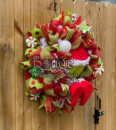 a christmas wreath hanging on the side of a wooden fence