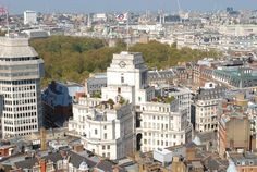 an aerial view of the city with tall buildings and trees in the foreground,