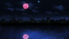 fireworks are lit up in the night sky over a body of water with city lights