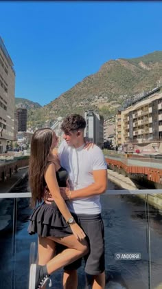 a man and woman standing next to each other in front of a cityscape