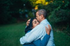 a man and woman embracing each other in the park